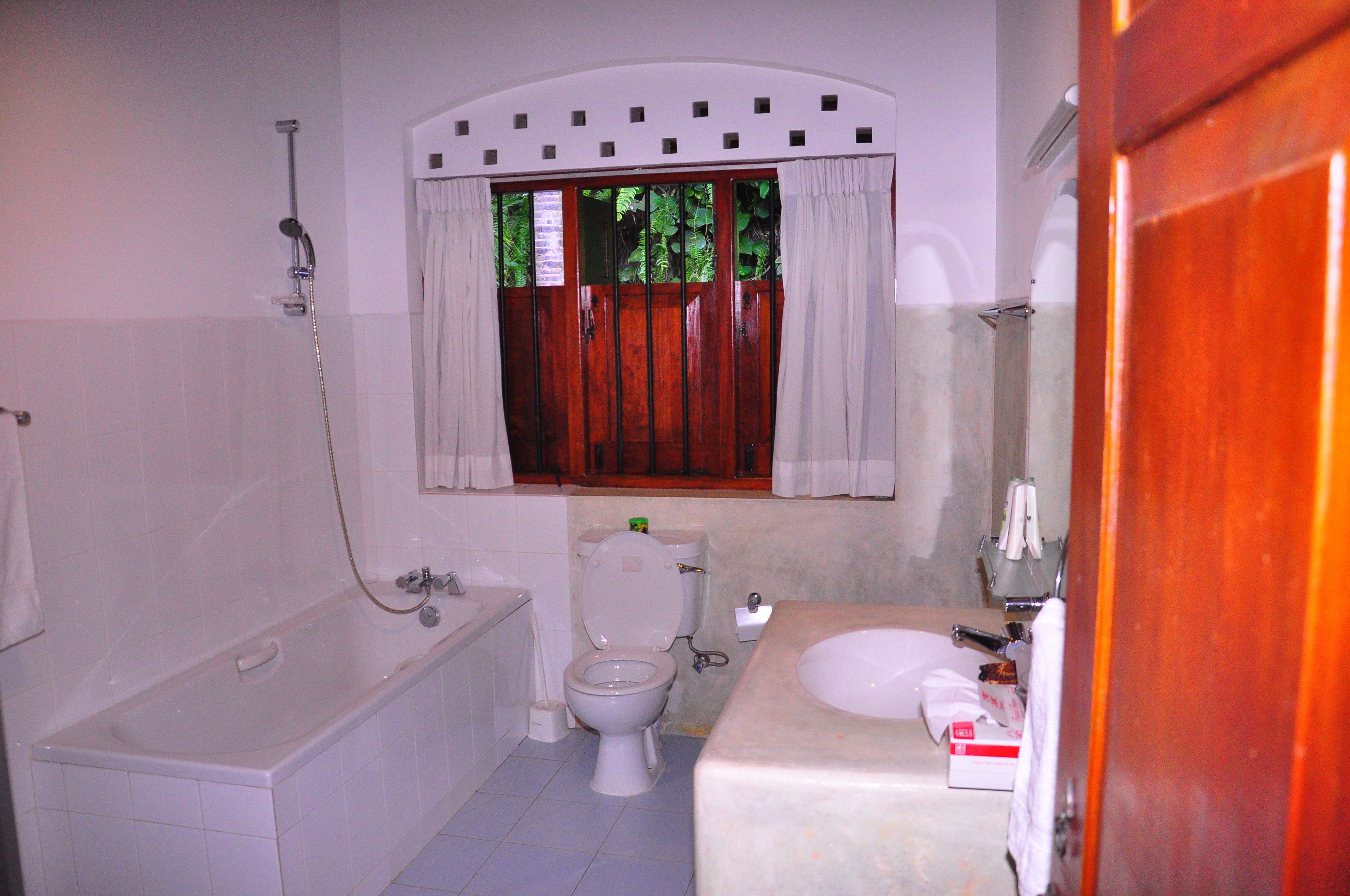 A bathroom with a bathtub, toilet, and sink.