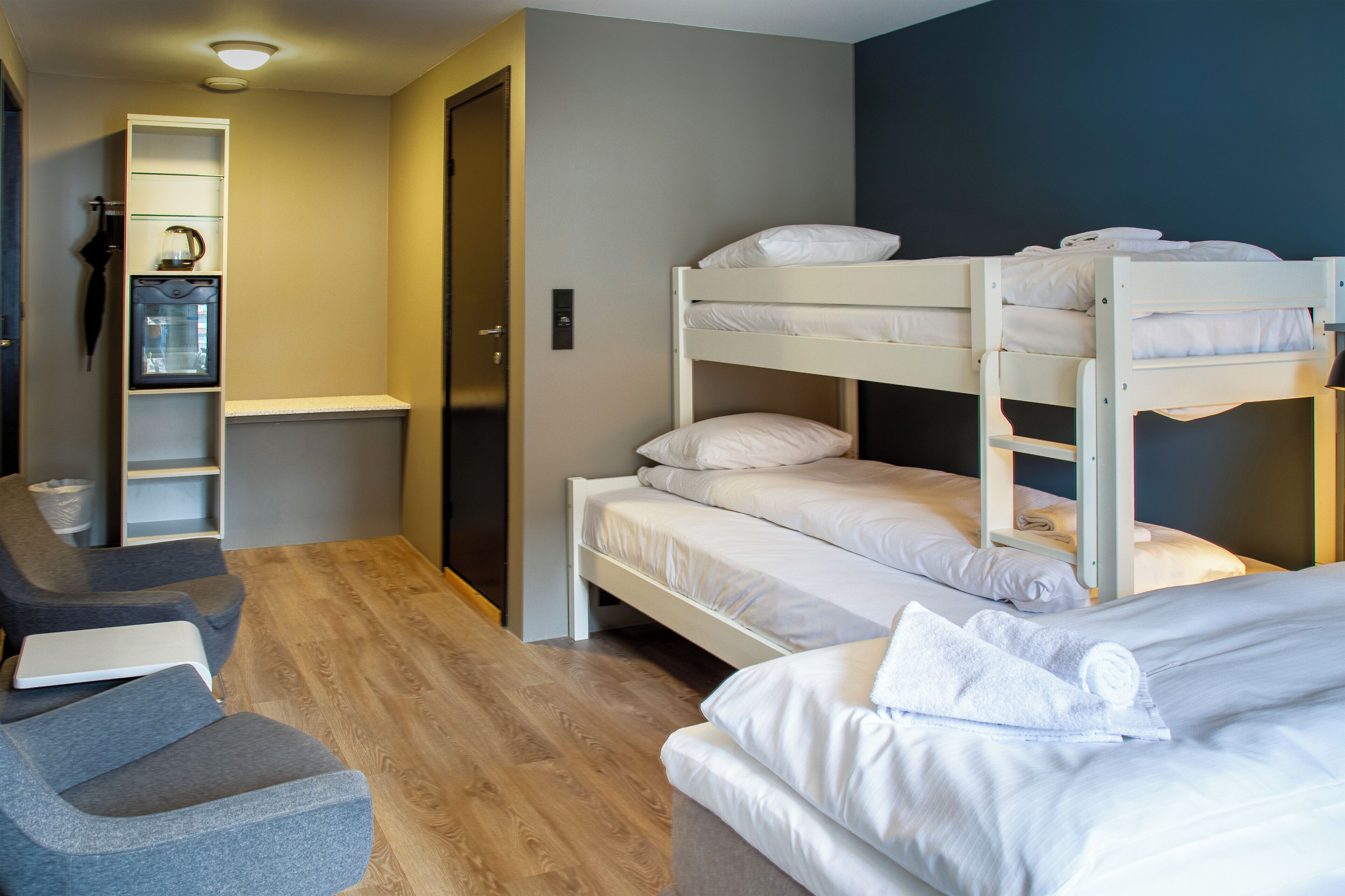 Ein Zimmer mit Etagenbetten, einem Schreibtisch und einem Stuhl.