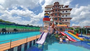 Piscina con varias toboganes y una zona de juegos infantiles.