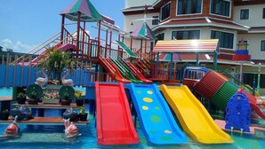 Parque acuático infantil con varias toboganes y una zona de piscina.