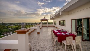 Una terraza en la azotea con comedor, un pabellón y vistas del paisaje.