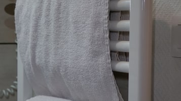 A white towel rack with two neatly folded towels.