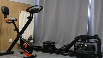 A stationary bike with a water bottle holder and a small step platform.