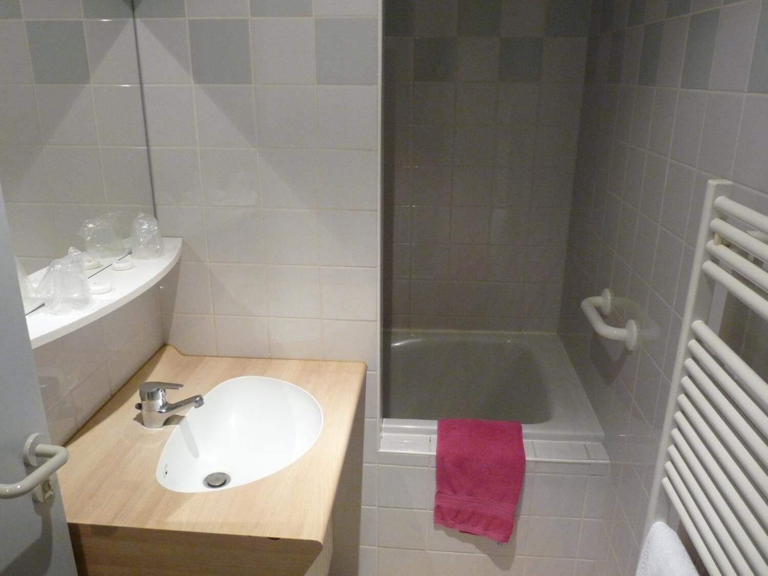 Un baño con lavamanos, espejo y ducha.