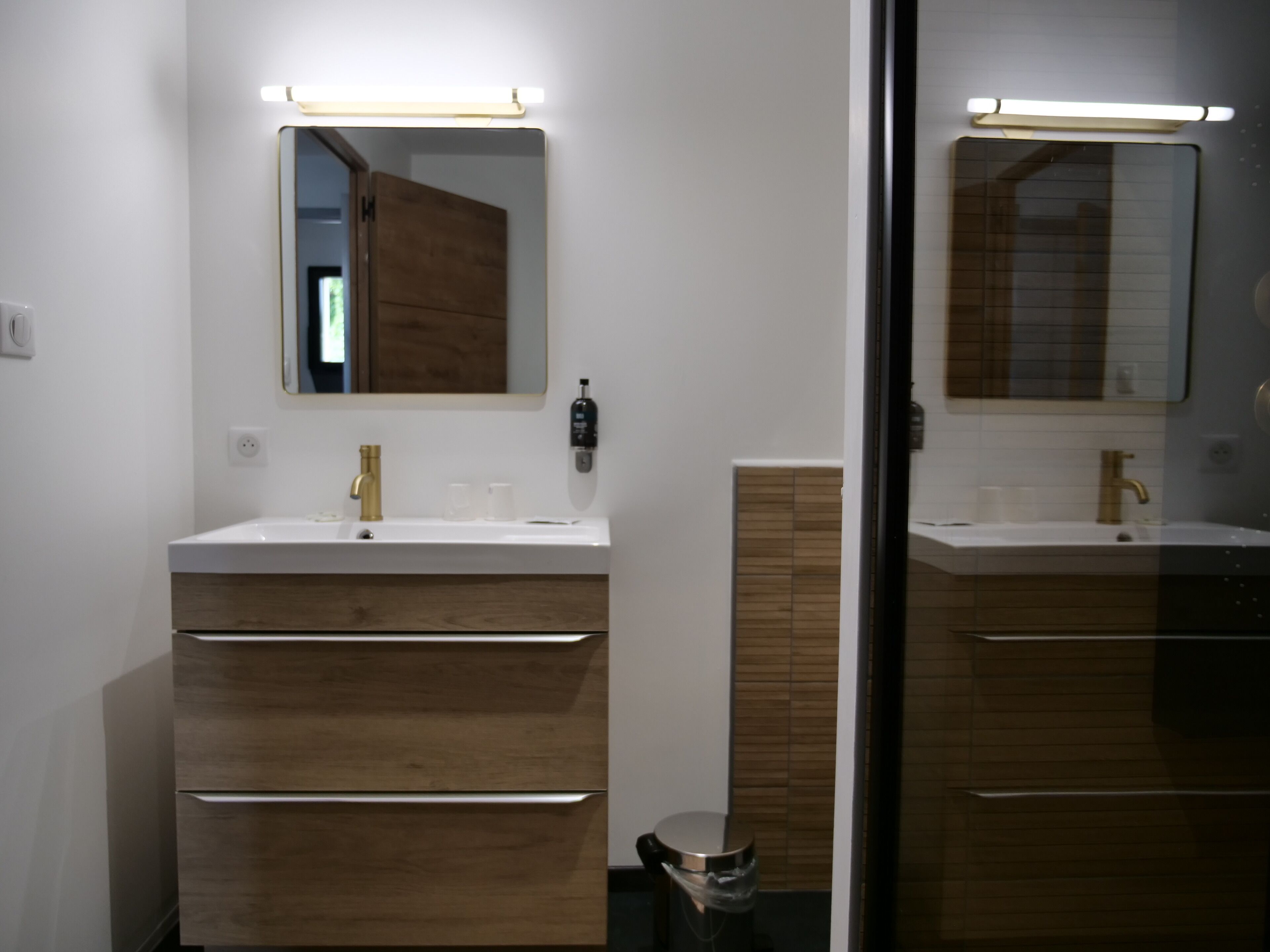 Une salle de bain moderne avec deux lavabos, des meubles en bois et un miroir.