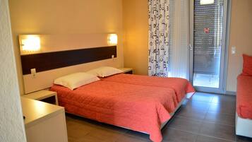 Habitación de hotel con cama, mesitas de noche, ventana con cortina y puerta.