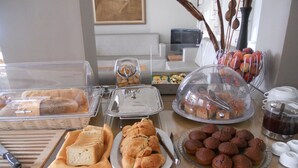 Un bufé con diversas opciones de panadería, incluyendo pan, pasteles y albóndigas.