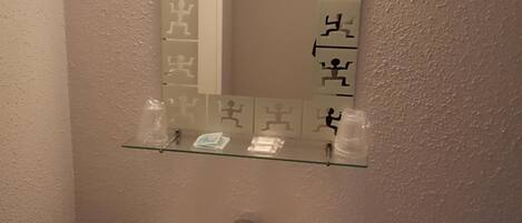 Un baño con un lavabo blanco, un espejo con figuras de ejercicios y un perchero para toallas.