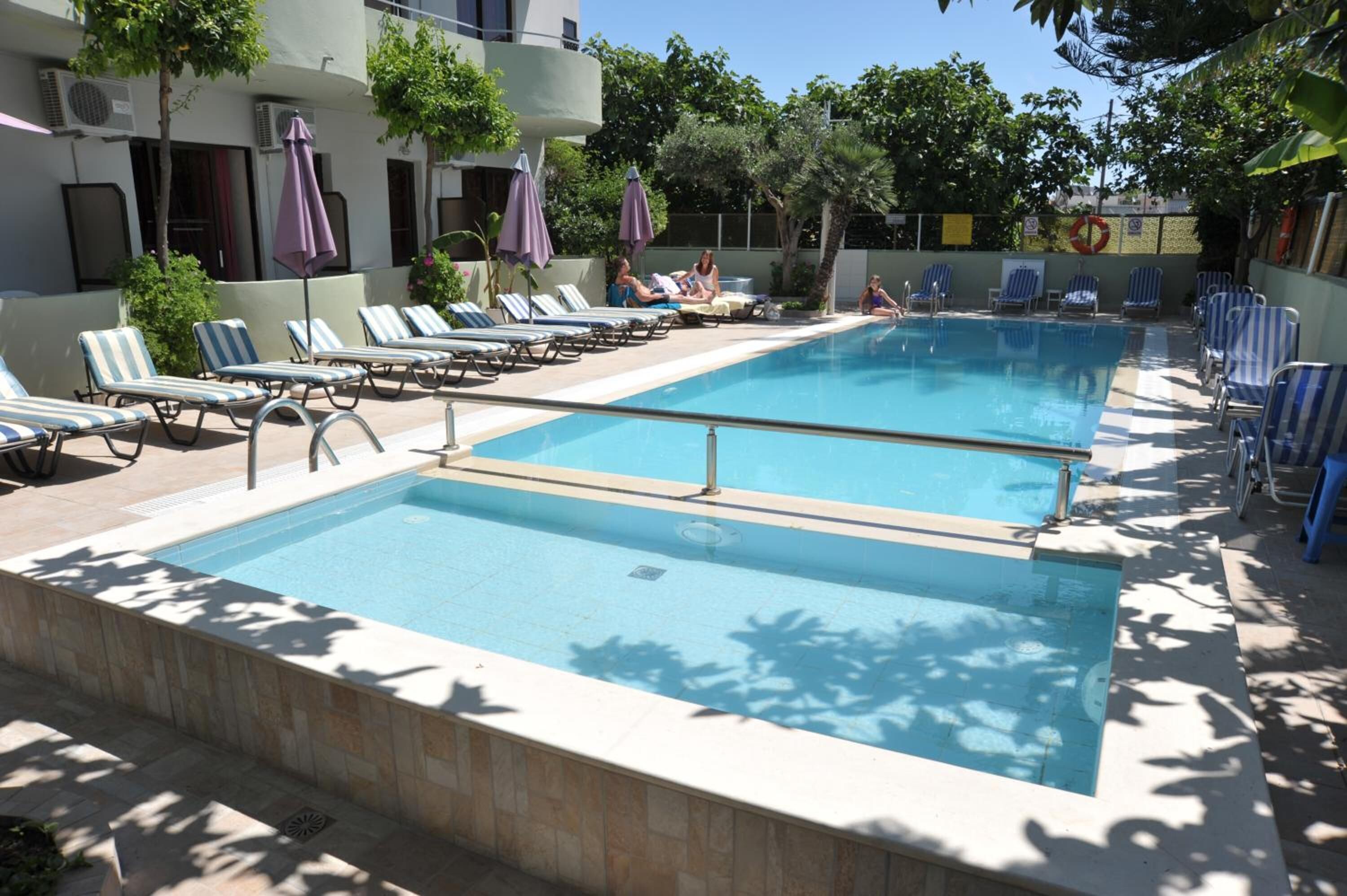 A pool area with lounge chairs and umbrellas.