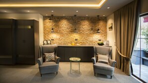 A modern living room with two sofas, a small table, and a stone wall. - Cityloft 24 (Istanbul)