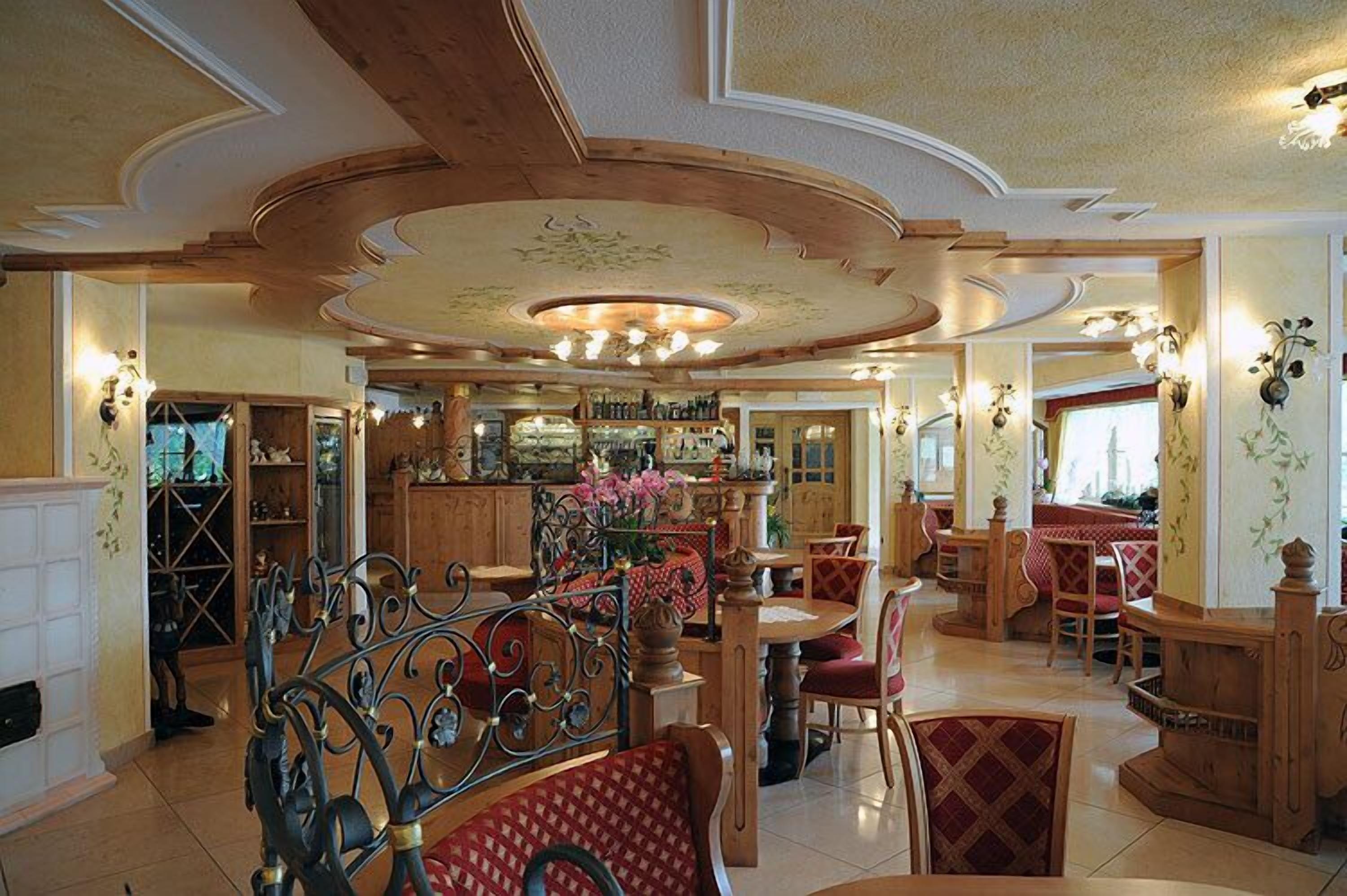Un'ampia sala da pranzo con arredi in legno e un lampadario centrale.