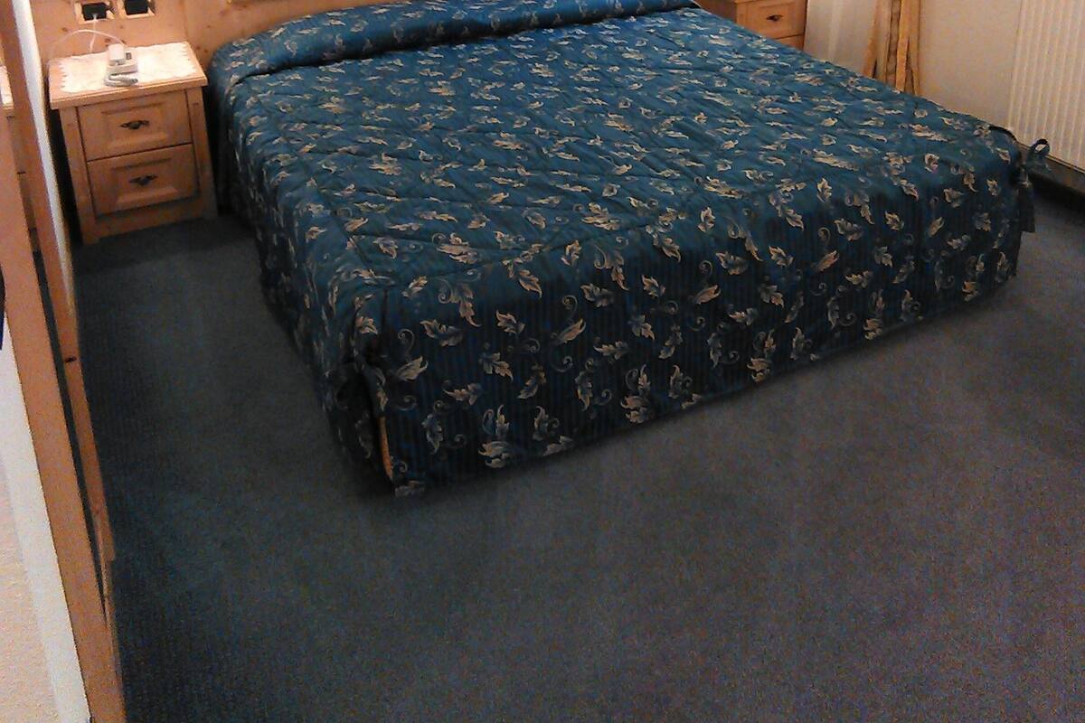Ein Schlafzimmer mit einem großen Bett, zwei Nachttischen und einem Beistelltisch.