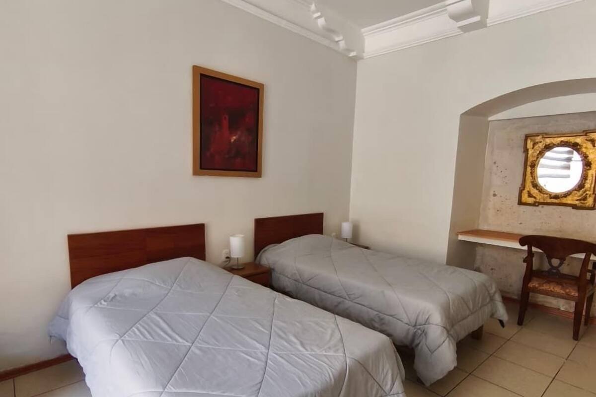 Une chambre avec deux lits, un bureau et une chaise.