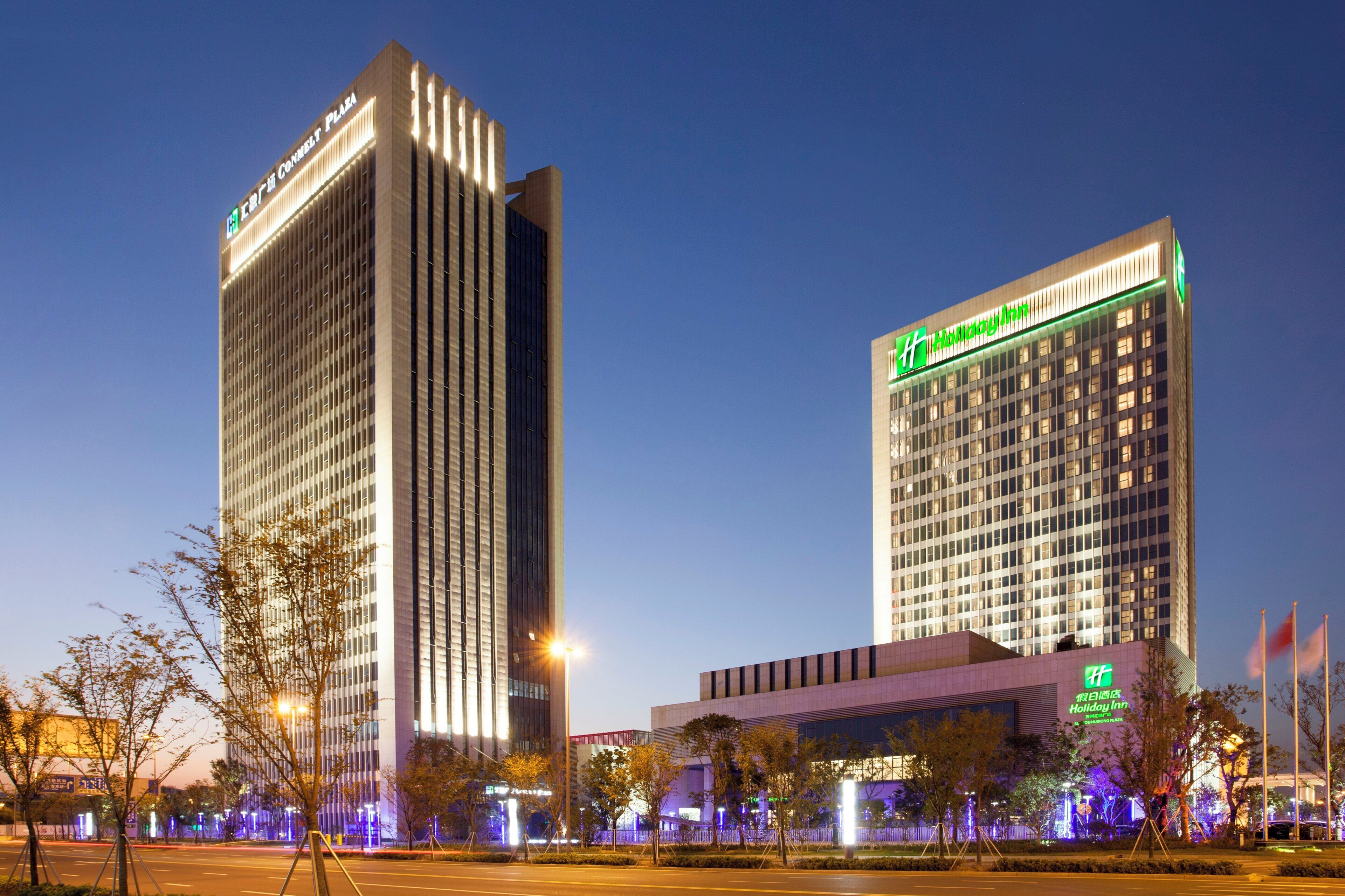 A hotel with a modern design, featuring a prominent Holiday Inn sign.
