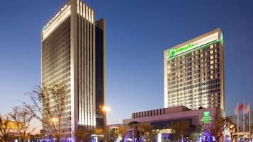 A hotel with a modern design, featuring a prominent Holiday Inn sign.