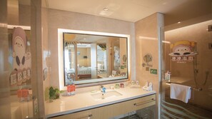 Une salle de bain d’hôtel avec un grand miroir, un lavabo et un espace douche.