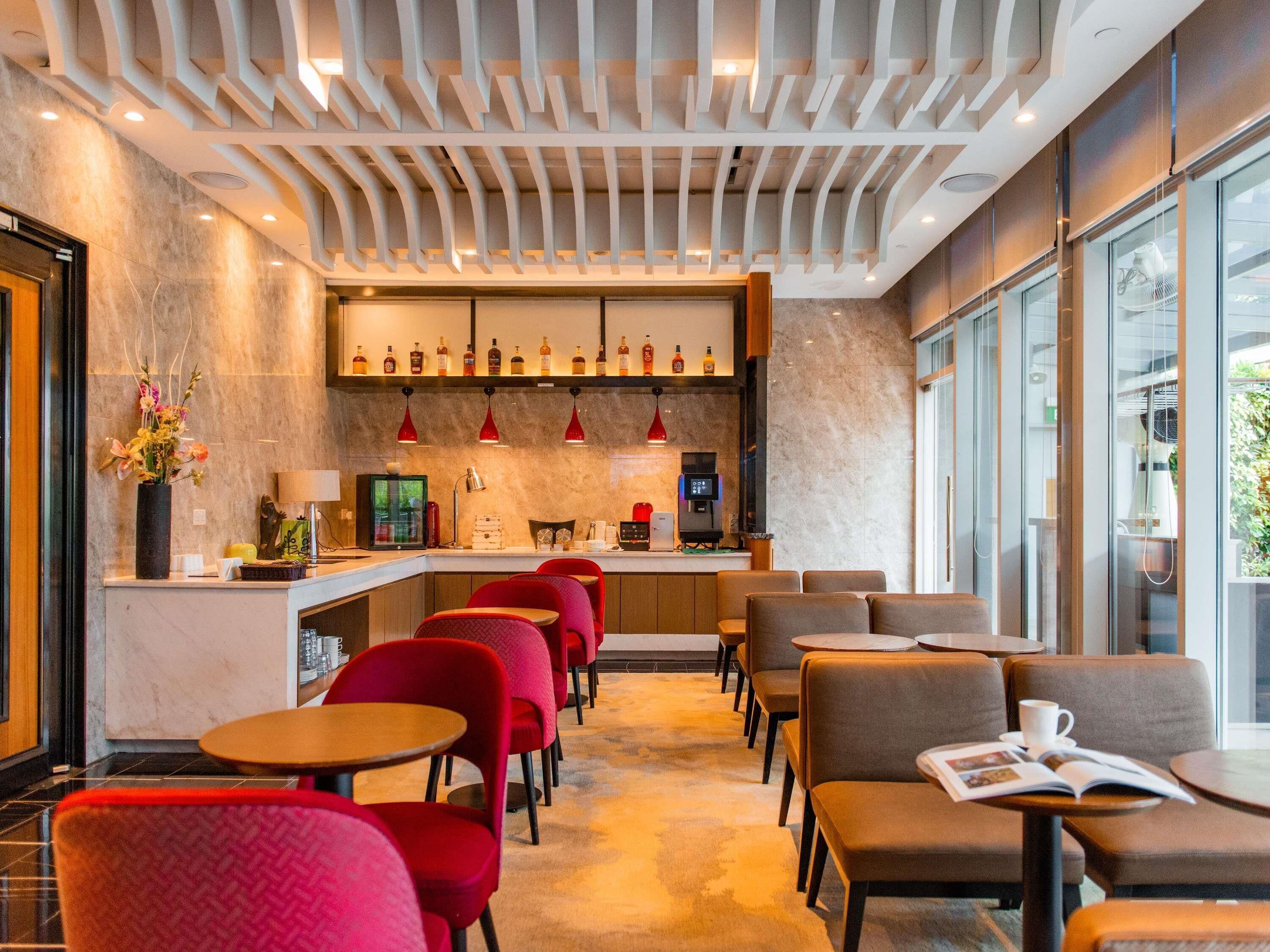 Eine moderne Bar mit Sitzgelegenheiten, einer Kaffeemaschine und einer Flaschenauslage.