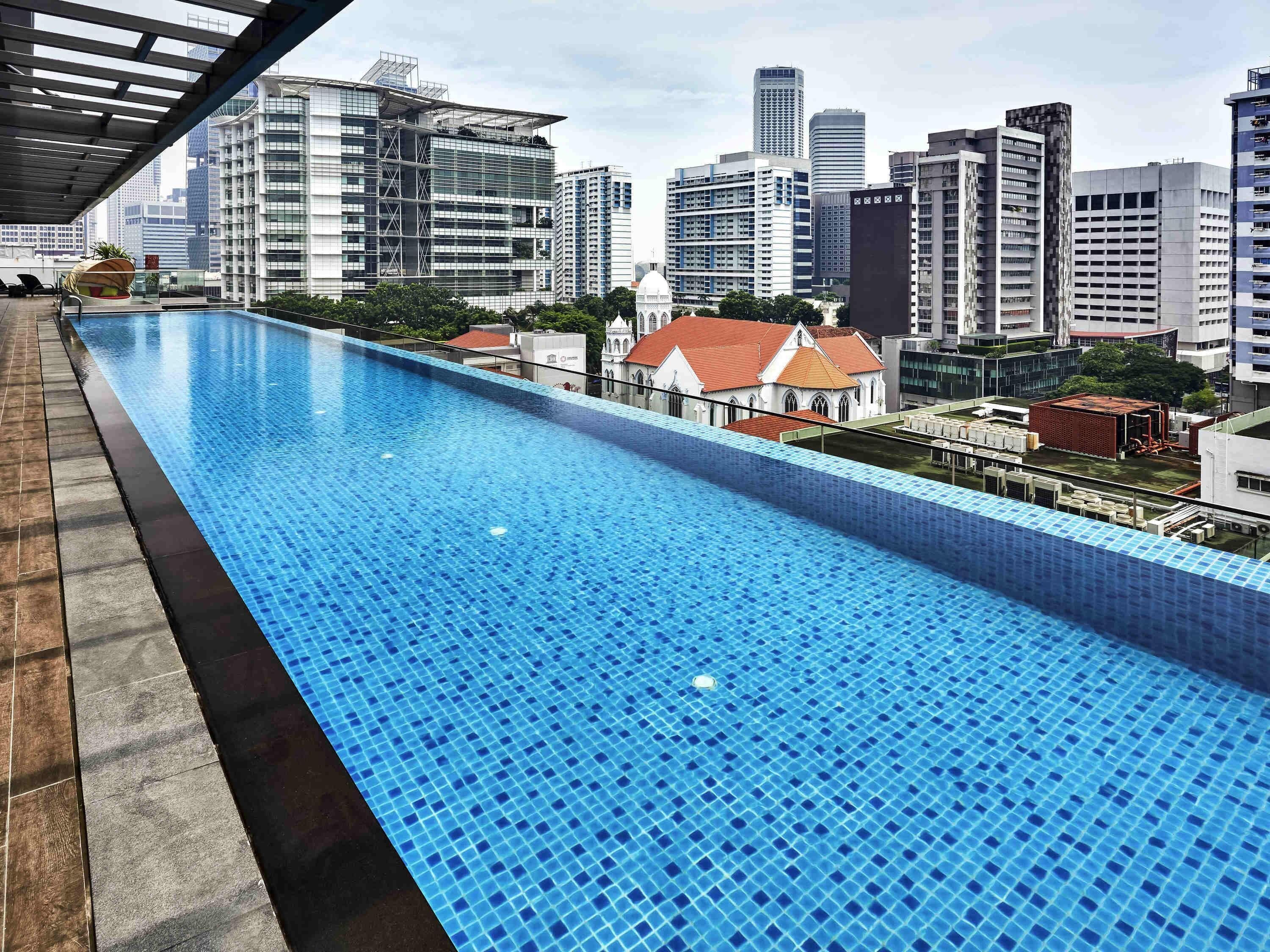 Una piscina infinita en la azotea con vistas a un horizonte urbano.
