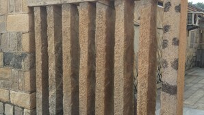 A stone balustrade with vertical columns and a flat top. - Tomato Red (Jinsha)
