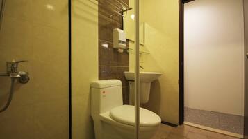 A bathroom with a toilet, sink, and shower.