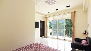 A spacious bedroom with a large bed, a sliding glass door leading to a balcony, and a modern ceiling design. - Shangti (Lugu)
