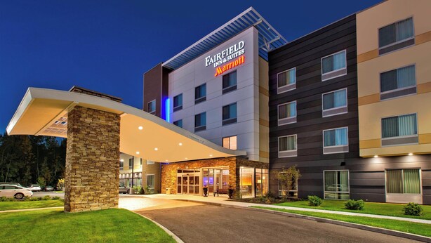 Ein Fairfield Inn & Suites Marriott Hotel mit moderner Außenansicht, einer überdachten Eingangspartie und einem gepflegten Rasen.