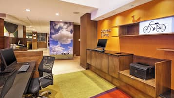 A reception area with a desk, computer, and printer.
