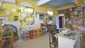 A cozy, well-lit room with a large window, a fan, and a table with a map. - Sea House homestay (Magong)