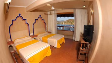 Une chambre d’hôtel avec deux lits, une télévision et une vue sur un plan d’eau.