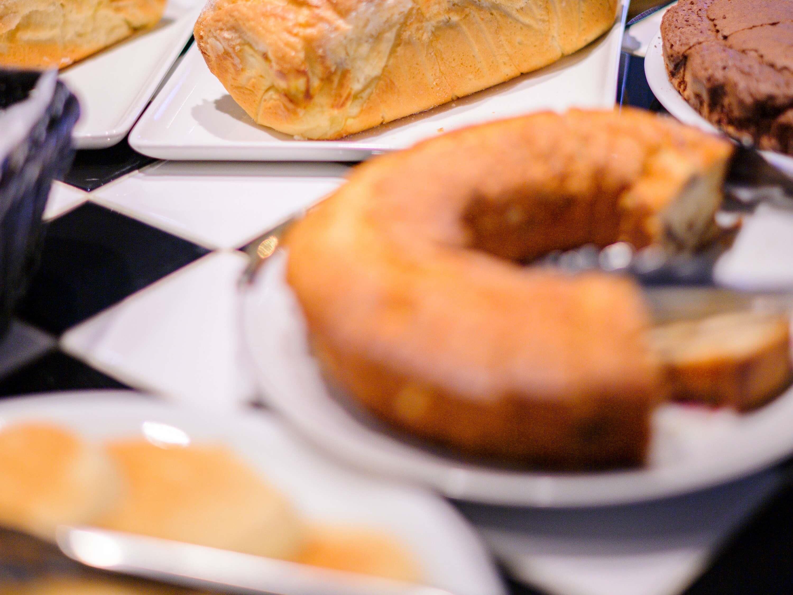 A variety of baked goods on plates, including a cake and a pie.