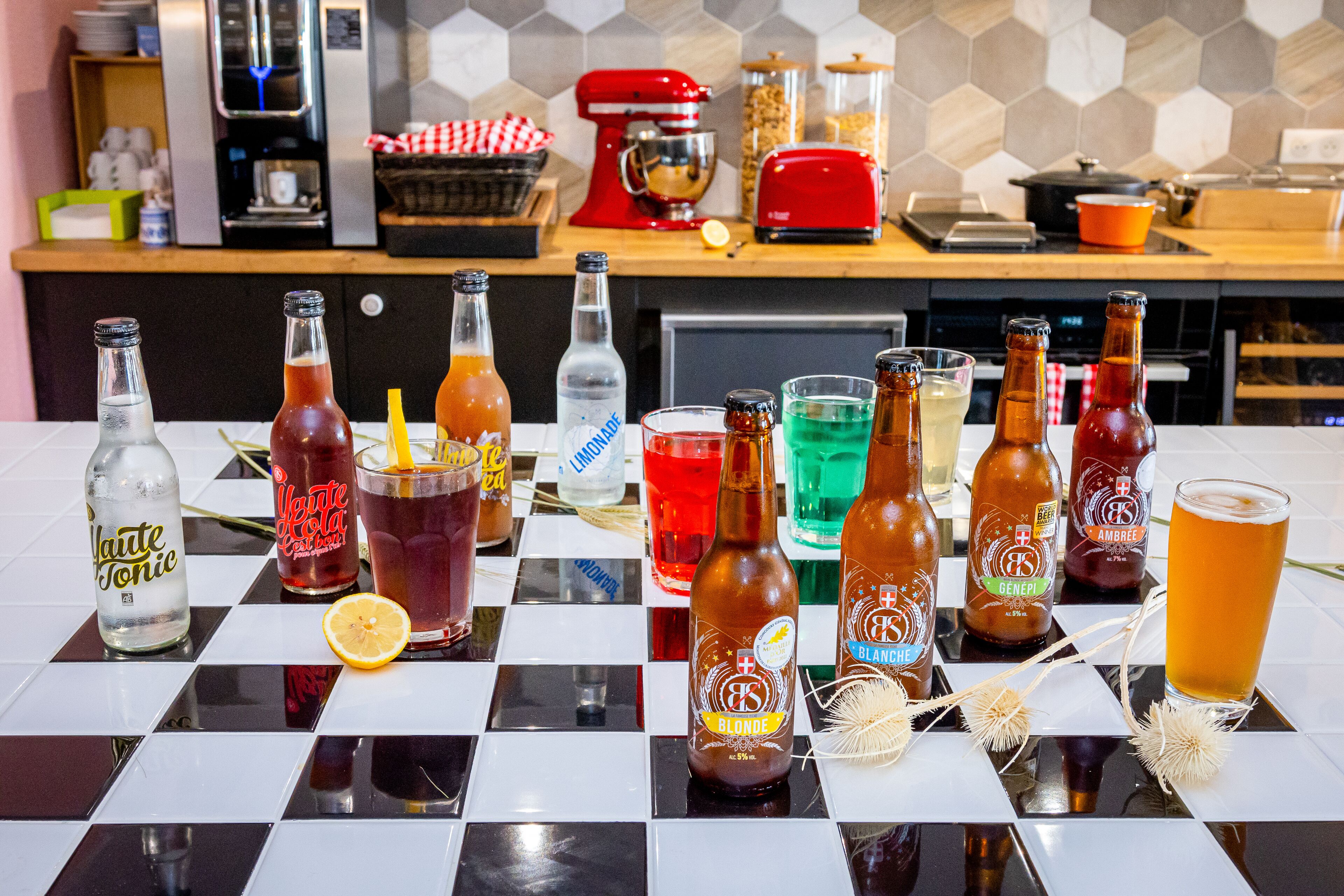 Una encimera de cocina con diferentes botellas y vasos de bebidas.