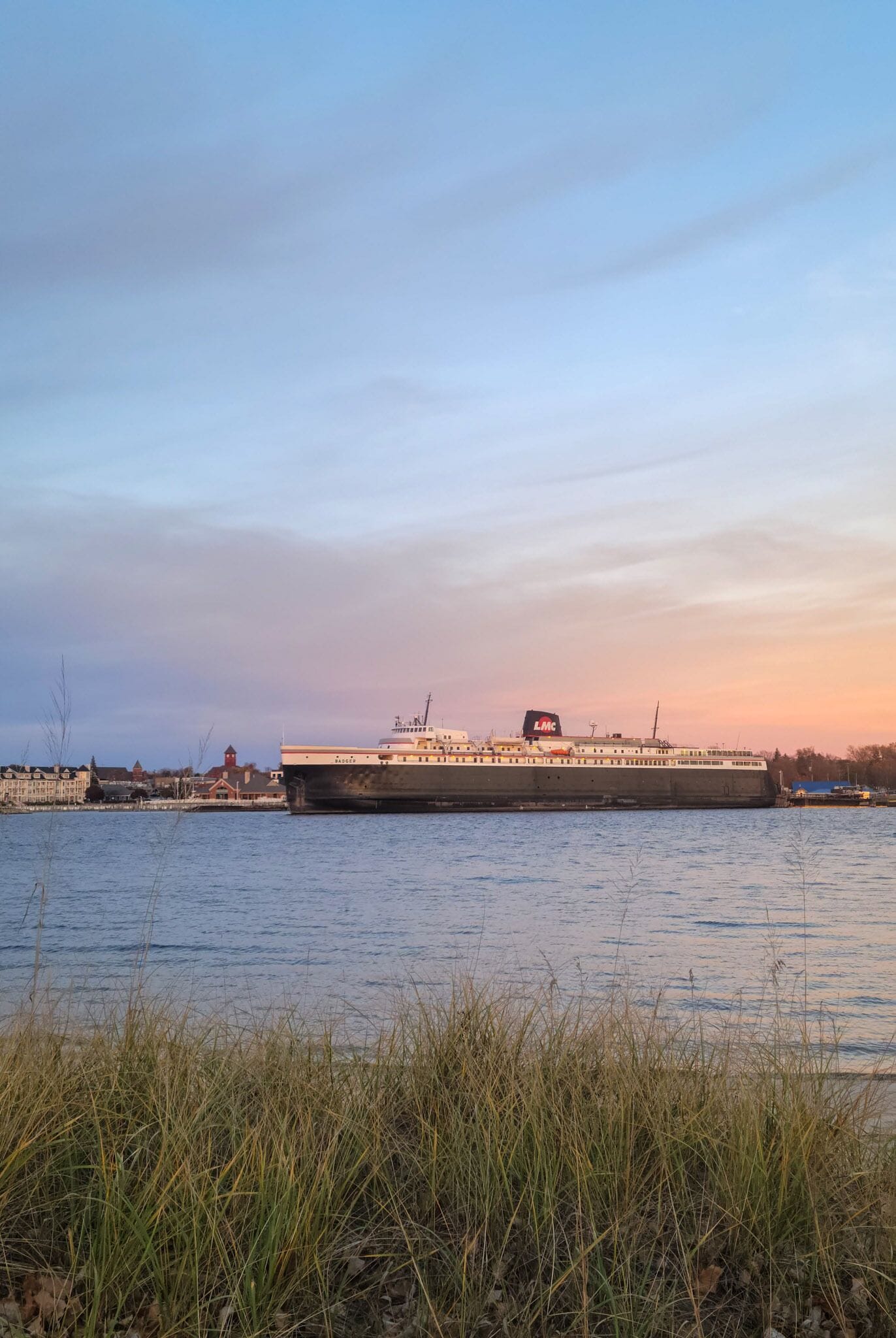 A large ship docked at a port with a clear sky.
