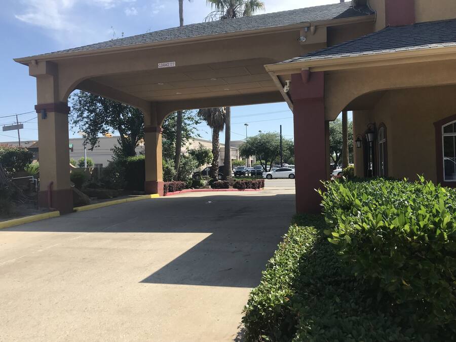 A building with a covered entrance and a parking lot.