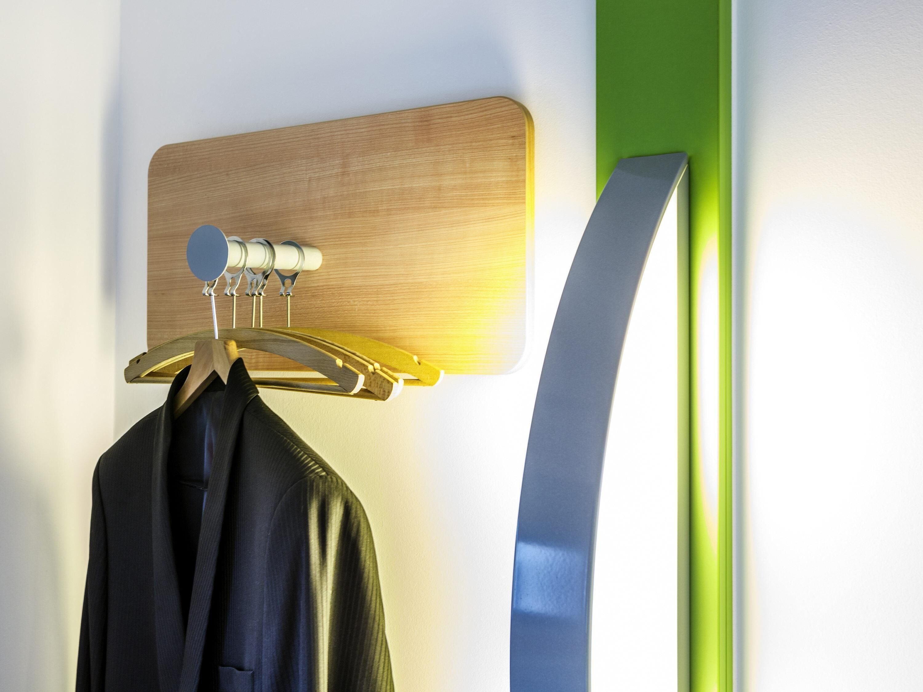 Percha de pared con panel de madera y una prenda colgada.