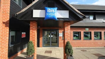 A hotel entrance with a sign for 'Ibis Budget Derby'.
