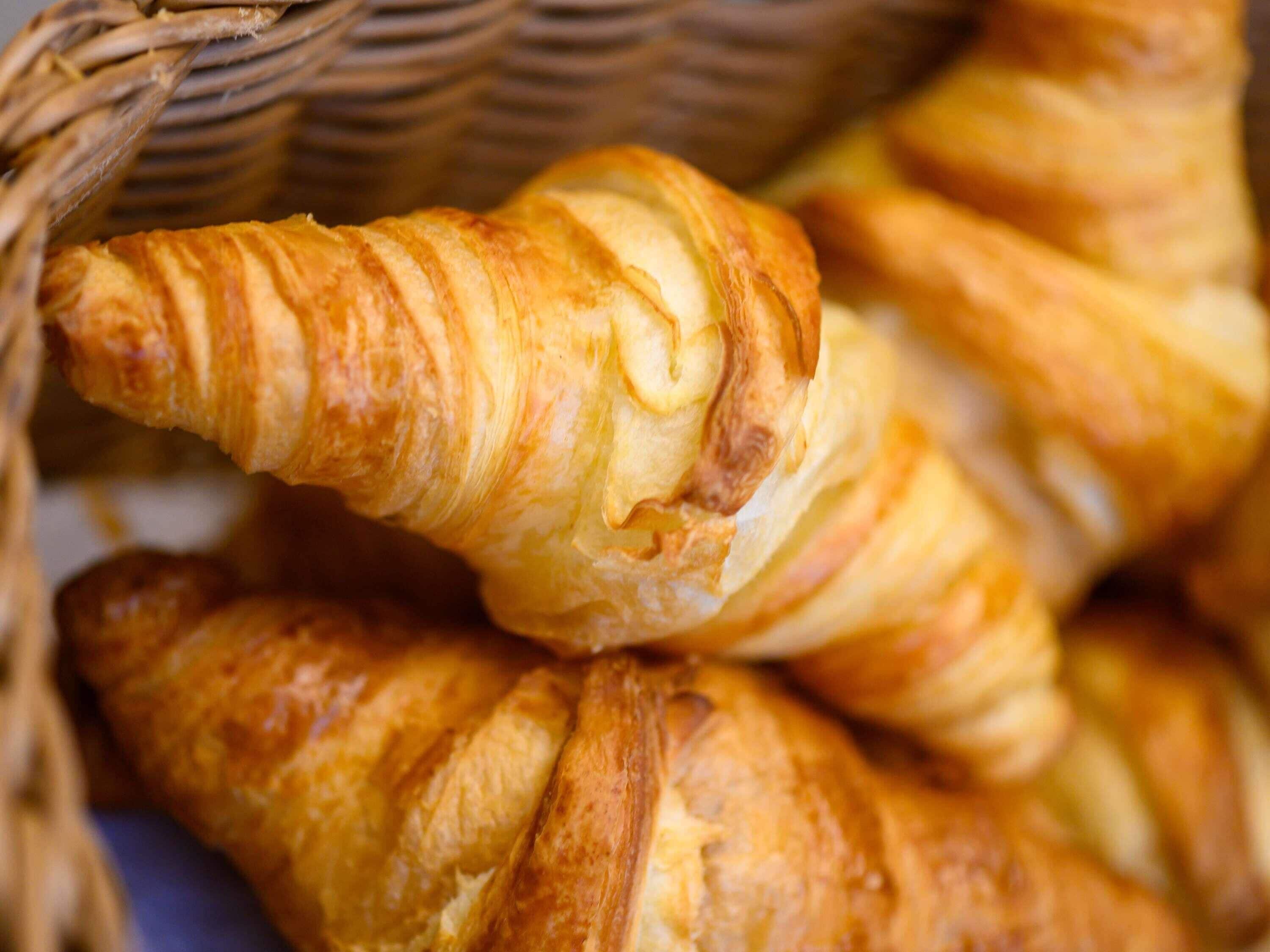 Una cesta con varios croissants dorados.
