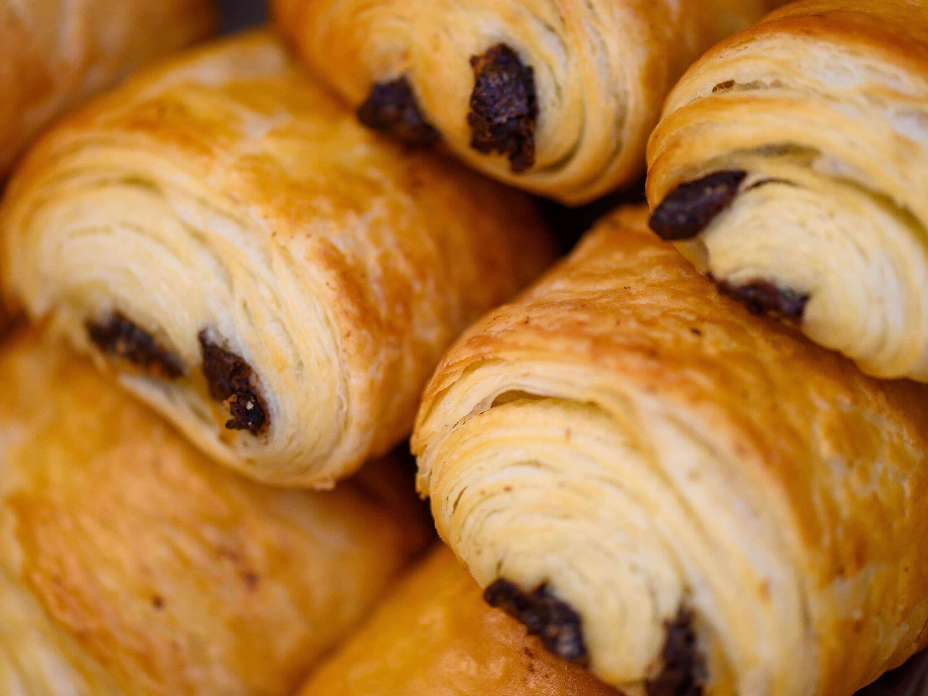 A close-up of a pastry with a golden-brown crust and visible dark filling.