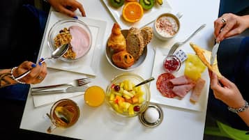 Una escena de desayuno con diversos alimentos y utensilios sobre una mesa.