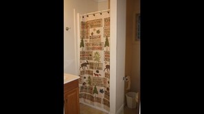 A bathroom with a shower curtain featuring wildlife and nature-themed designs. - Green Haven Resort (Lake George)