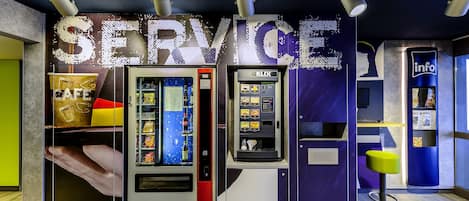 A service kiosk with a vending machine and a self-service counter, featuring a prominent 'SERVICE' sign.