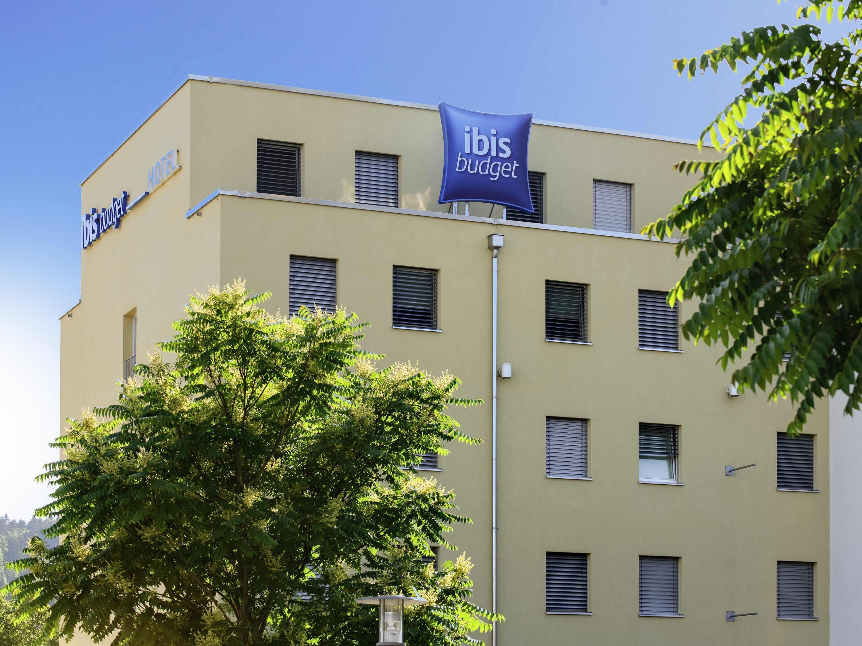 Ein Hotelgebäude mit zahlreichen Fenstern und einem Schild mit der Aufschrift 'ibis budget'.