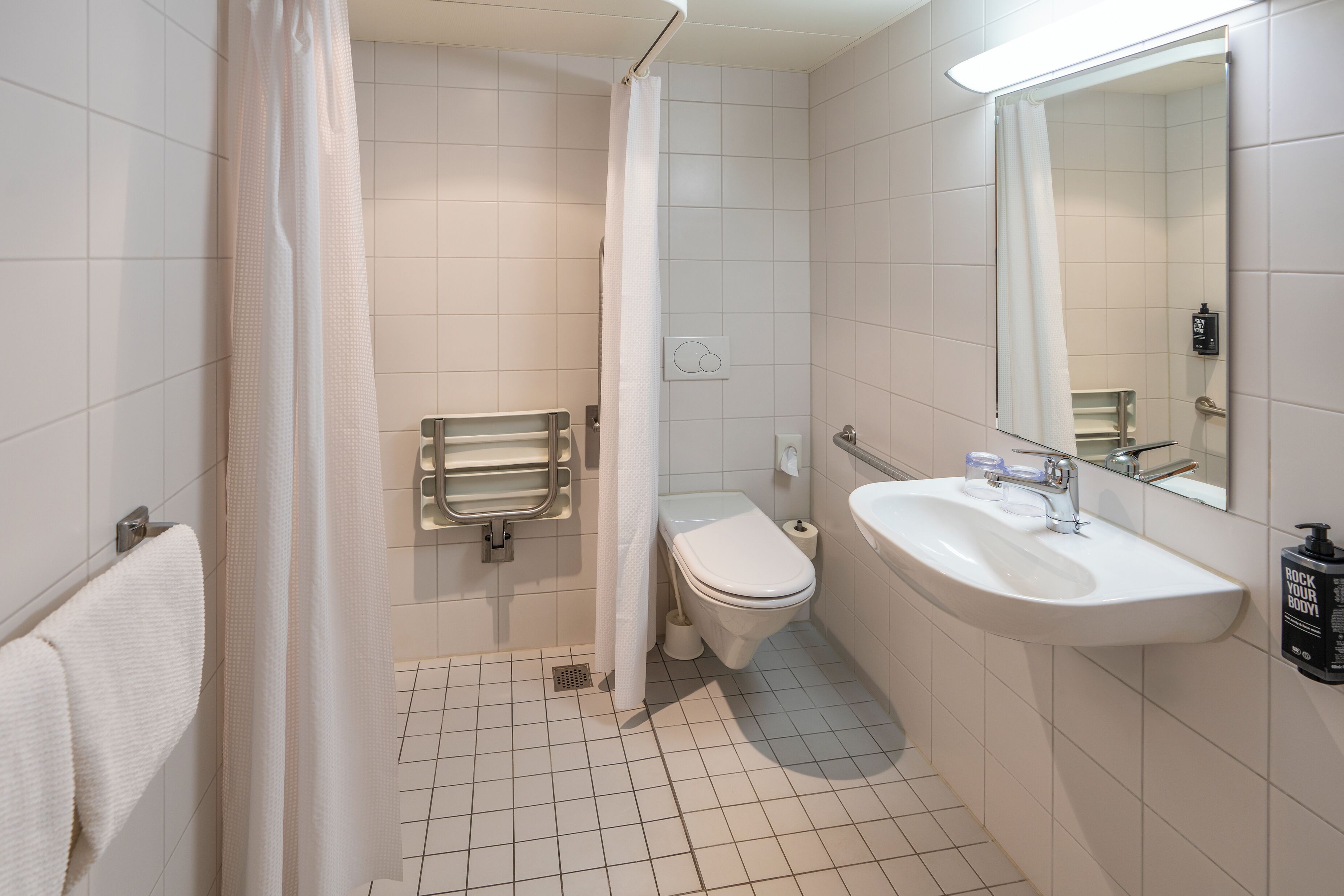 A bathroom with a toilet, sink, and shower curtain.