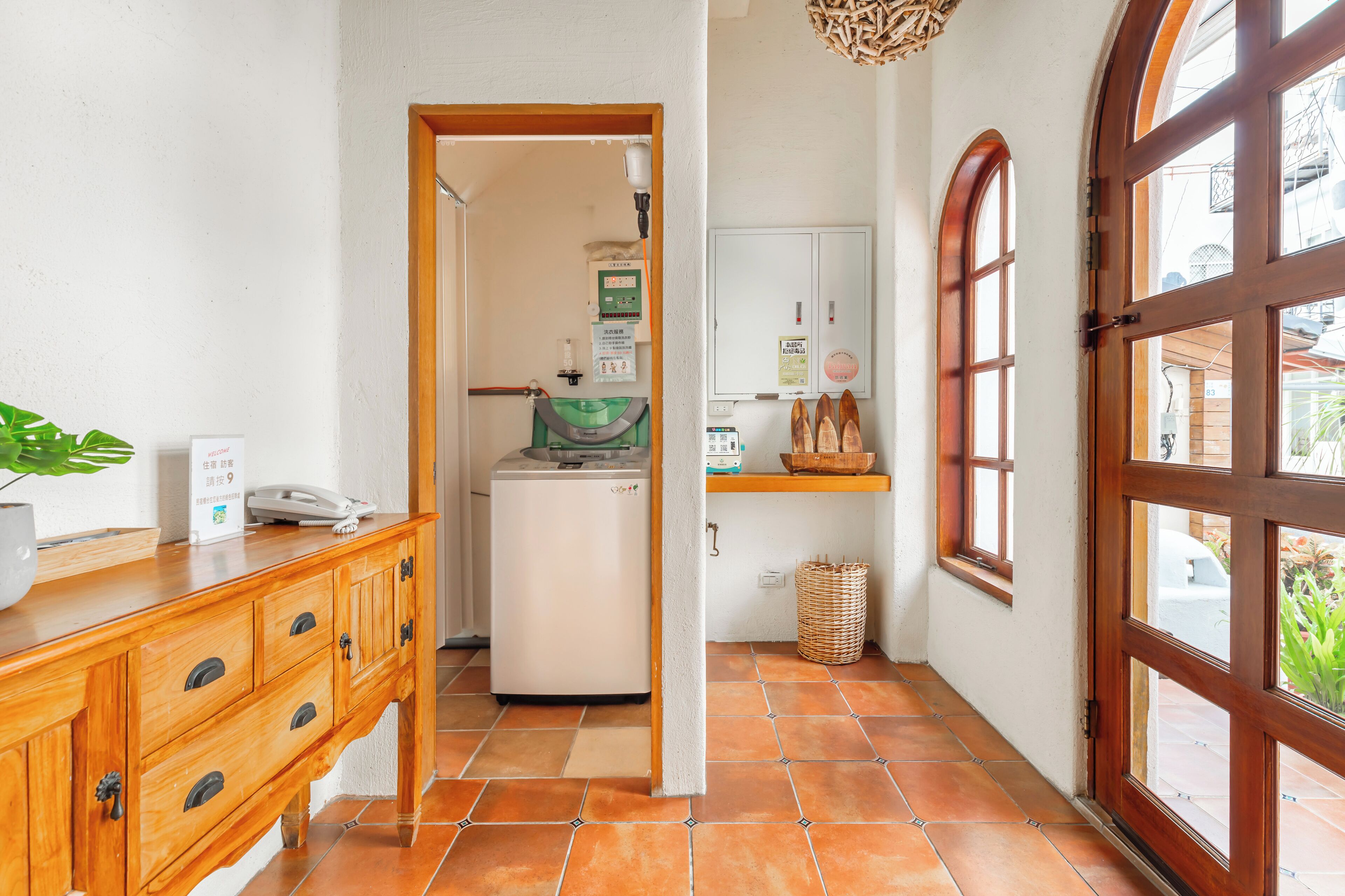 Passadís estret amb un armari de fusta, un refrigerador petit i una finestra que dona a l'exterior.