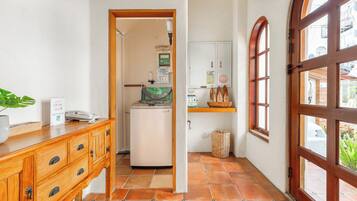 Passadís estret amb un armari de fusta, un refrigerador petit i una finestra que dona a l'exterior.