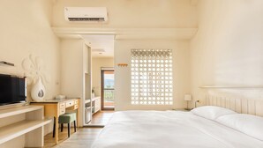 A bedroom with a bed, a desk, a chair, a TV, and a window with a view. - Kenting Fairyland & Farm Guest House (Hengchun)