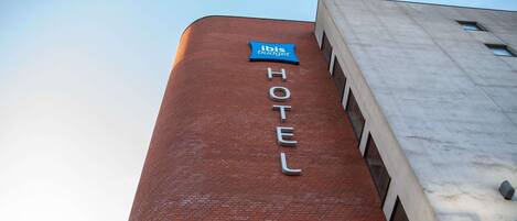 A hotel with a brick facade and a sign indicating it is part of the ibis budget hotel chain.