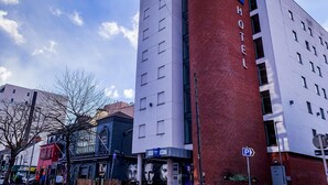Un hotel con una imponente torre de ladrillo rojo y un letrero que indica que es un hotel.