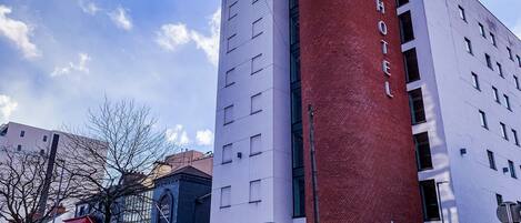 Un hôtel doté d’une imposante tour en briques rouges et d’une enseigne indiquant qu’il s’agit d’un hôtel.