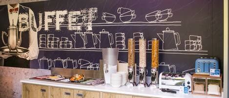 Un comptoir de buffet où sont présentés divers plats et ustensiles de cuisine.