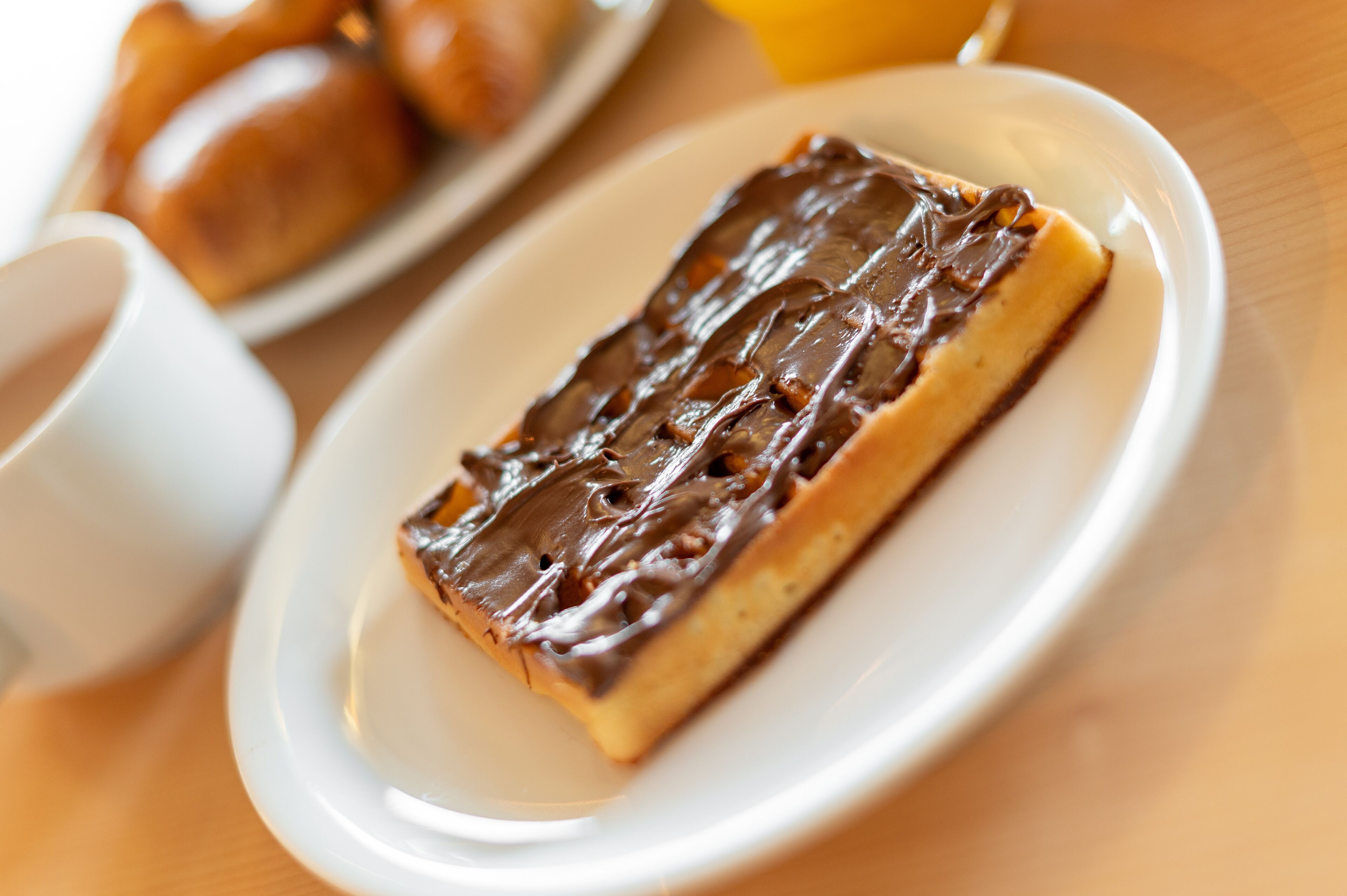 A dessert on a plate with a cup beside it.